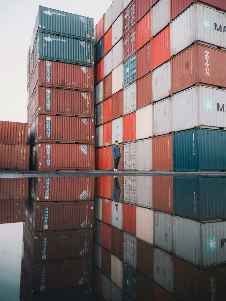 Man Standing Near A Stack Of Cargo Containers